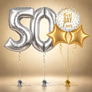 Large silver 50th birthday foil number balloons with two gold star-shaped balloons, a white Best Day Ever balloon with gold and silver confetti dots, and coordinating ribbons and balloon weights against a champagne gold background.